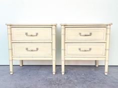 two white nightstands side by side with handles on each end and one drawer open