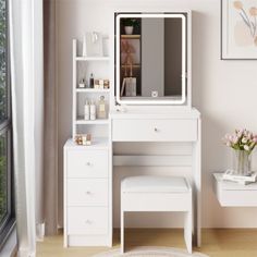 a white dressing table with drawers and a mirror