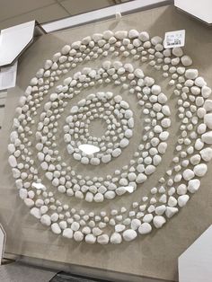 there are many white rocks arranged in the shape of a spiral on top of a table