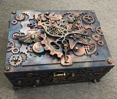 an intricately designed metal box sitting on the floor with gears all over it's surface