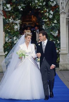 the bride and groom are walking down the blue carpet