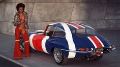 a woman standing next to a blue and red car