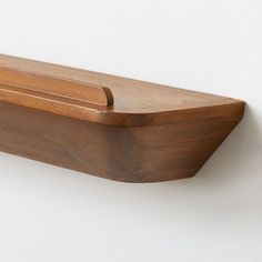 a wooden shelf mounted to the side of a wall