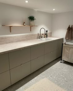 a kitchen area with sink, counter and shelves