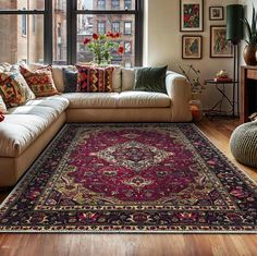 a living room filled with furniture and a large rug on top of a hard wood floor