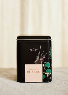 a close up of a canister on a bed with a label that says plukt