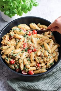 a bowl filled with pasta and vegetables on top of a table