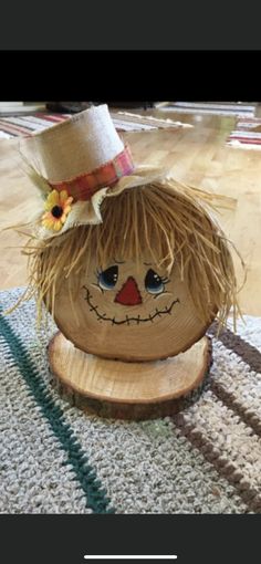 a scarecrow head is sitting on top of a piece of wood