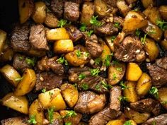 some meat and potatoes in a pan with parsley sprigs on the side