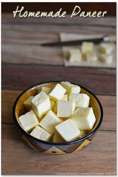 a bowl filled with cubed tofu sitting on top of a wooden table