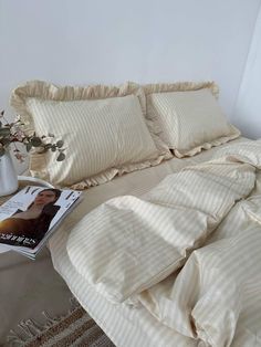 a bed that has some pillows on it and a magazine in front of the bed