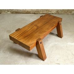 a wooden bench sitting on top of a cement floor