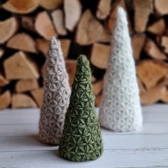 three small knitted trees sitting next to each other