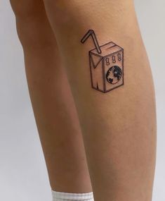 a woman's legs with a small tattoo of a box and a globe on it