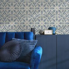 a blue couch sitting in front of a wall with a clock on top of it