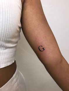 a woman's arm with the letter c tattooed on her left arm, in black ink