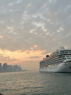 a large cruise ship in the water near a city