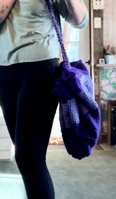 a woman is holding a purple bag and talking on the phone while wearing leggings