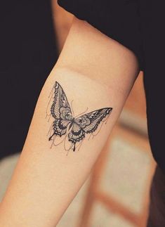 a small butterfly tattoo on the right forearm and arm, it is black and white