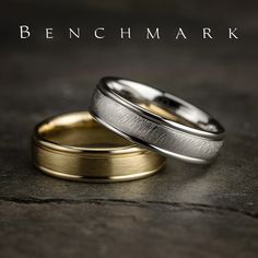 two gold and silver wedding bands with the words benchmark written on top of them