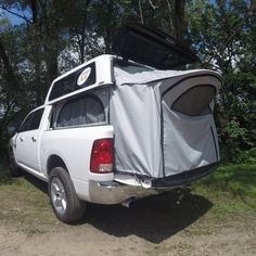 the back end of a white truck with an awning on it's roof