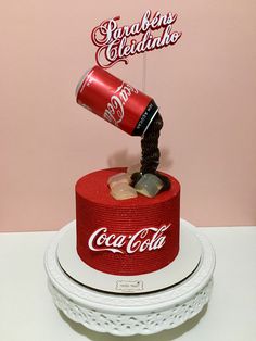 a coca - cola cake with a coke can pouring it into the cup and rocks on top