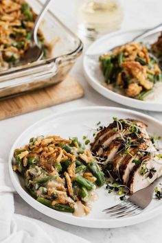 two white plates topped with chicken and green beans next to a casserole dish