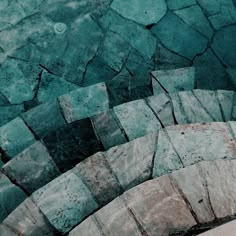 an abstract photo of stone steps in the middle of a pool with water running down them