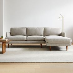 a couch sitting on top of a white rug in a living room next to a table