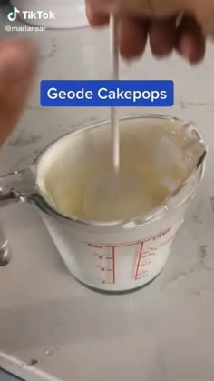 someone is mixing some cake batter in a measuring cup