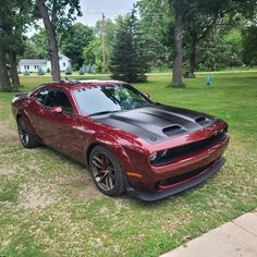 a red and black car parked in the grass