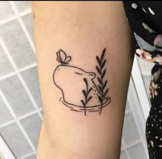 a woman's arm with a small tattoo of a dog and flowers on it