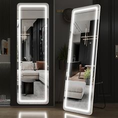 two large mirrors with lights on them in the middle of a room, one is illuminated and the other has a couch