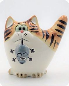 a ceramic figurine of a cat holding a mouse