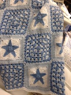 a blue and white crocheted blanket with stars on it