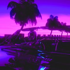 a car parked in front of a palm tree at night with the sun going down