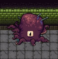 an octopus is laying on the ground in front of a brick wall