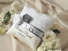 a wedding ring pillow and flowers on a bed