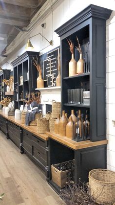 a store filled with lots of shelves and vases on top of wooden tables next to each other