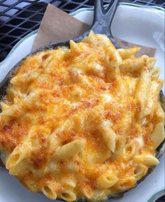 a white plate topped with macaroni and cheese on top of a metal pan