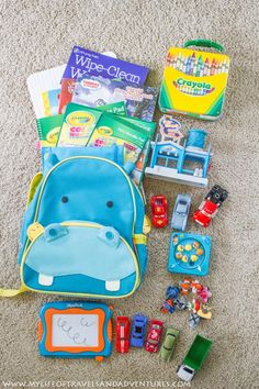 the contents of a toddler airplane bag laid out on the floor