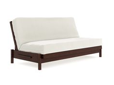 a white couch with wooden frame and arm rests against a white wall, it is isolated from the camera