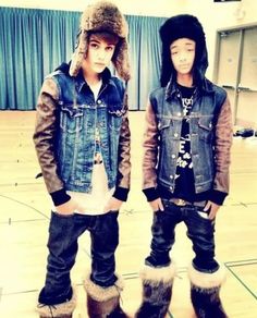 two young men standing next to each other on a basketball court wearing boots and jackets