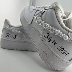 a pair of white sneakers with pearls on them