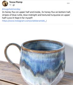 a blue and white coffee cup sitting on top of a wooden table next to a tweet