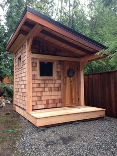 a small wooden outhouse sitting on top of gravel