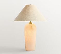 a table lamp with a white shade on it and a beige fabric lampshade