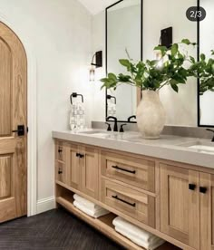 a bathroom with double sinks and wooden cabinets