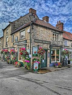 an old brick building with flowers on the outside