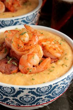 two bowls filled with shrimp and grits on top of a table